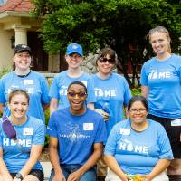 Alumni pose in front of the Alumni House